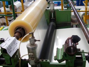 Rollo de película protectora PDS aplicada sobre láminas metálicas en línea industrial